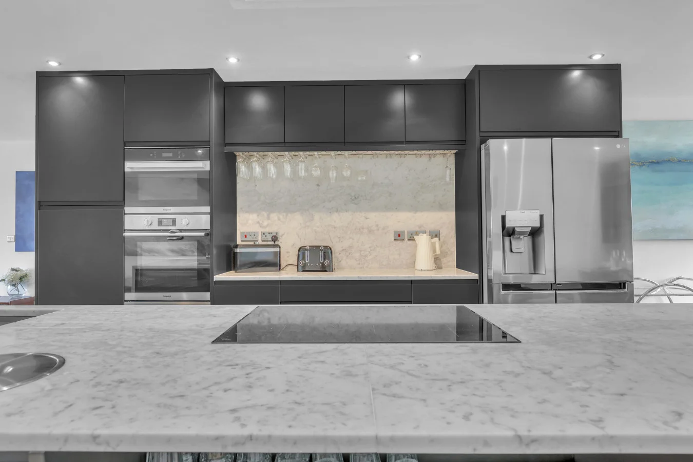 Premium kitchen featuring double ovens and American fridge freezer