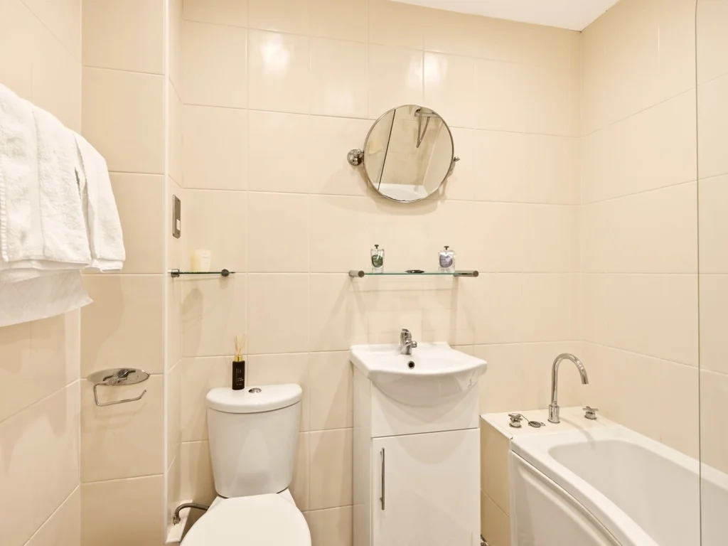 Family bathroom with bath, wash basin and heated towel rail.