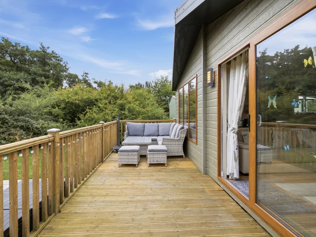 Wraparound deck with outdoor lounge seating beside the lodge