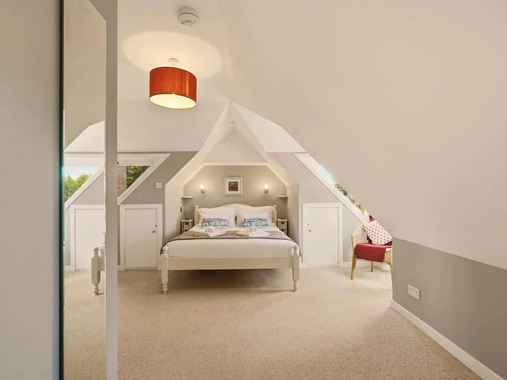 Bright king bedroom with mirrored wardrobe and peaceful countryside outlook