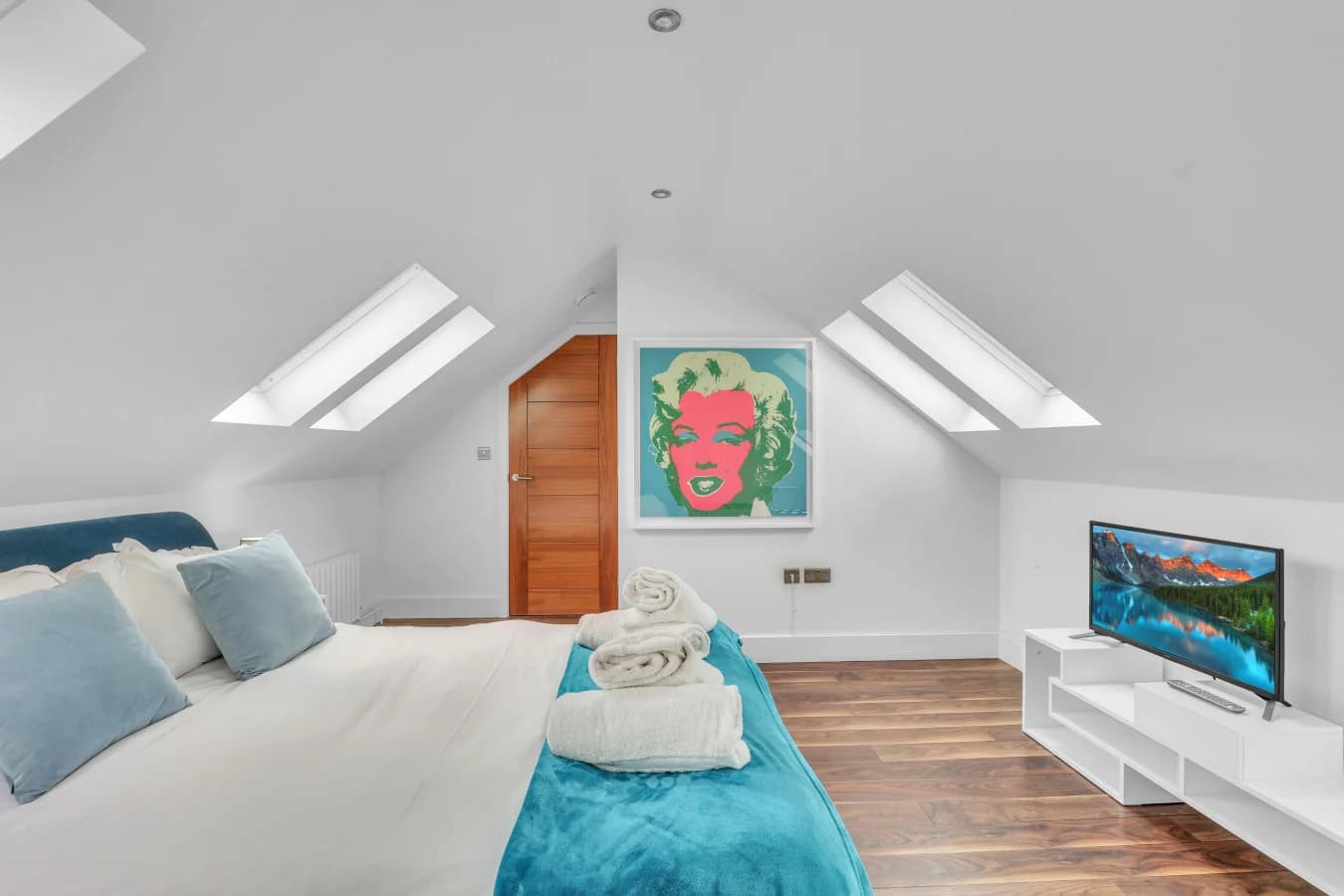 Spacious bedroom with Smart TV and contemporary artwork