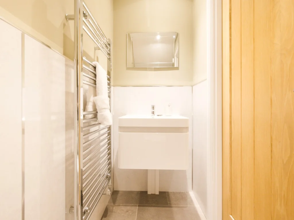 Downstairs WC with compact wash basin and heated towel rail