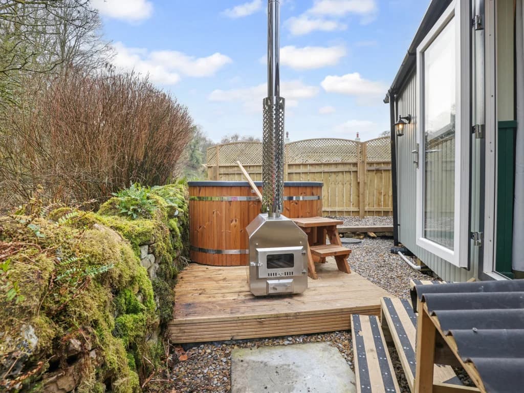 Charming outdoor space featuring a wood-fired hot tub and seating area