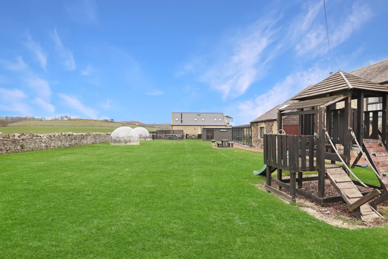 Landscaped lawn with play area and countryside views