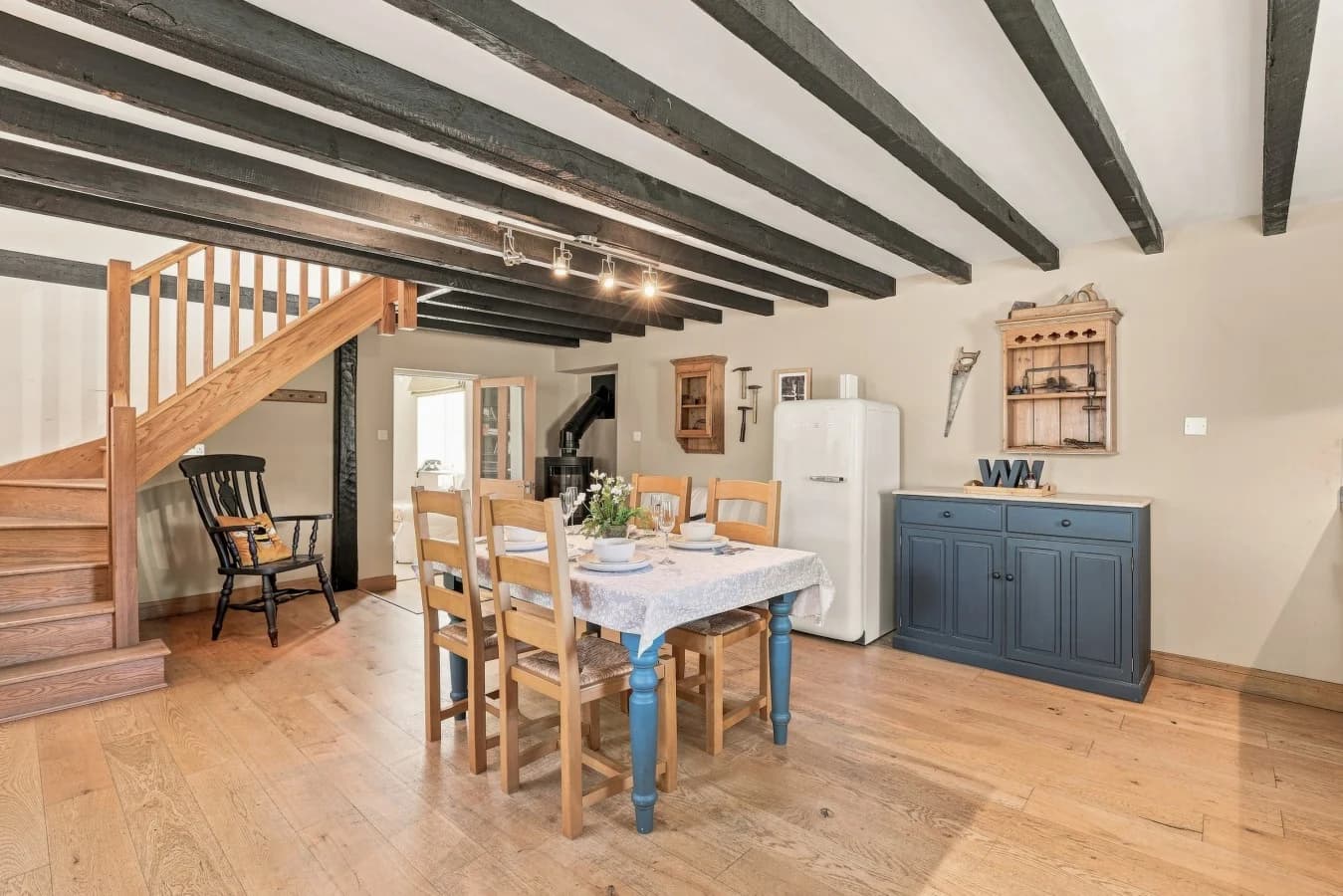 Spacious dining area with wooden staircase and exposed beams