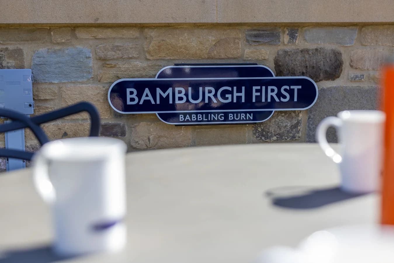 Patio dining area with Bamburgh First cottage sign