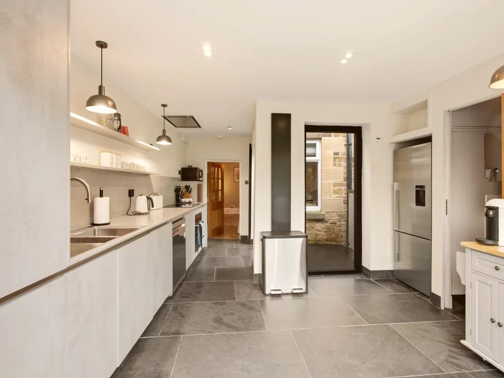 Spacious modern kitchen with extensive worktops and integrated appliances.