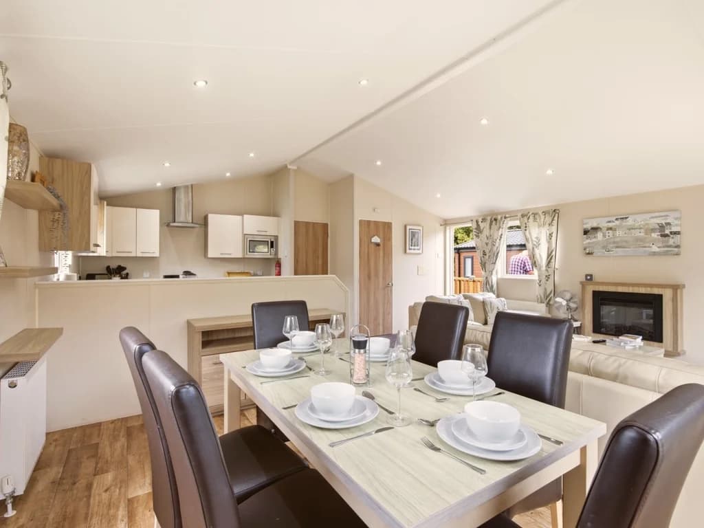 Dining table set for six beside the open-plan kitchen and living area