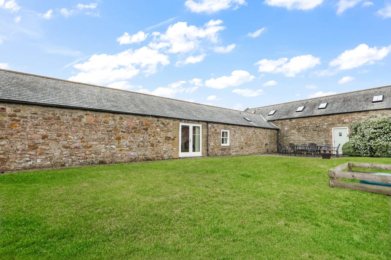 Large enclosed garden surrounded by traditional stone buildings