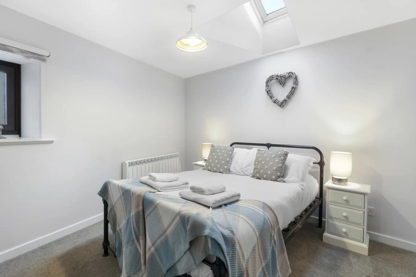 Peaceful bedroom with bedside lighting and vaulted ceiling