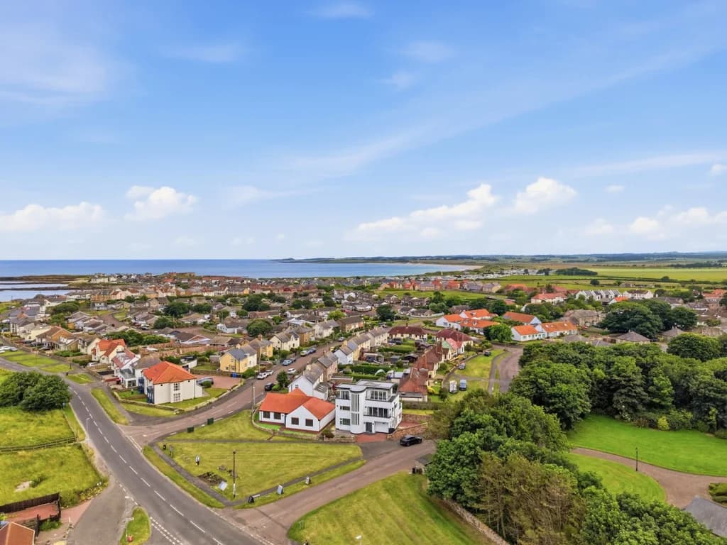 Sweeping aerial view of Beadnell village, coastline and beautiful sandy beaches