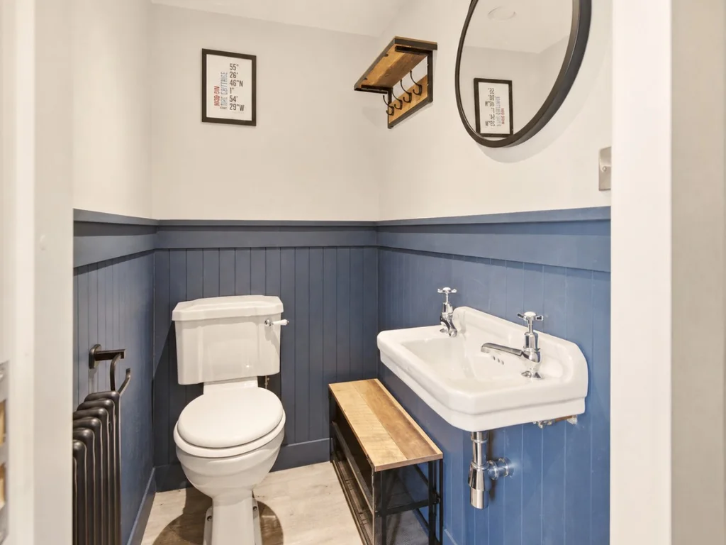 Convenient cloakroom with traditional basin, WC and blue panelled walls