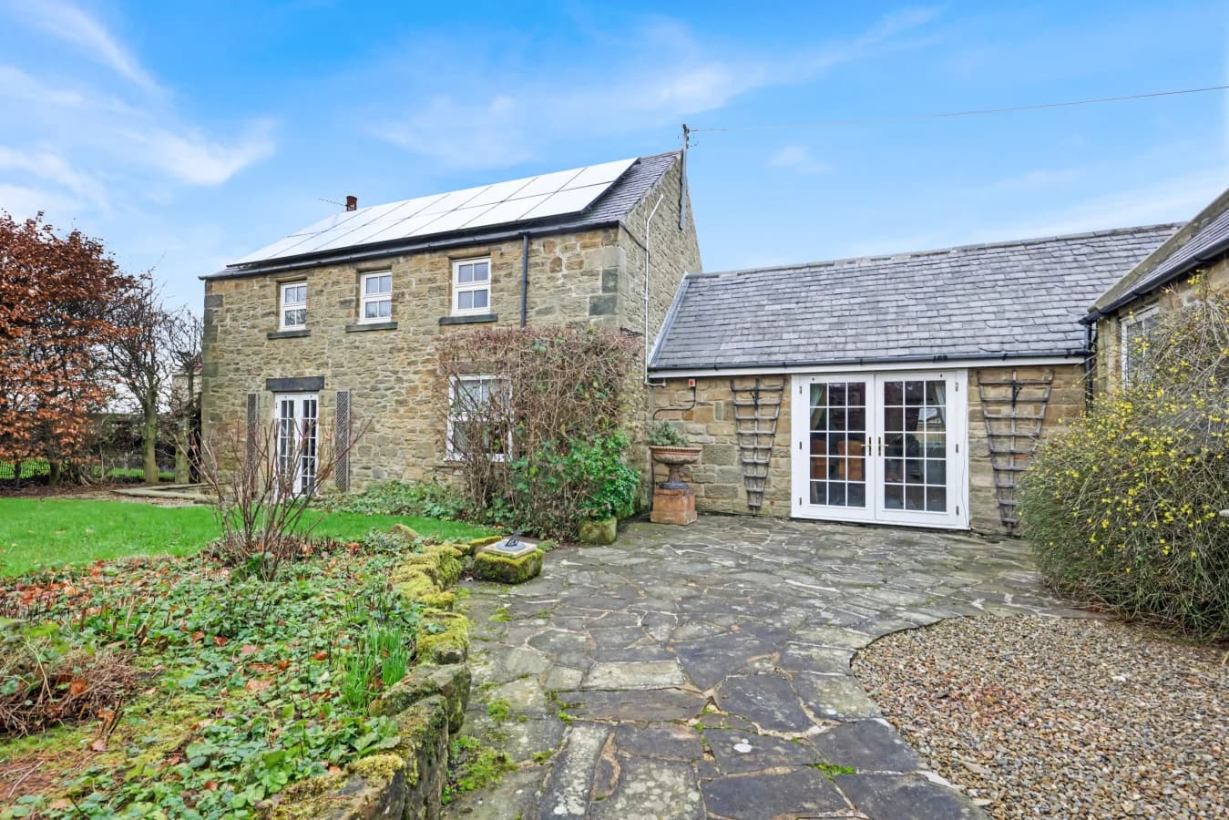 Stone patio linking the farmhouse to its landscaped gardens
