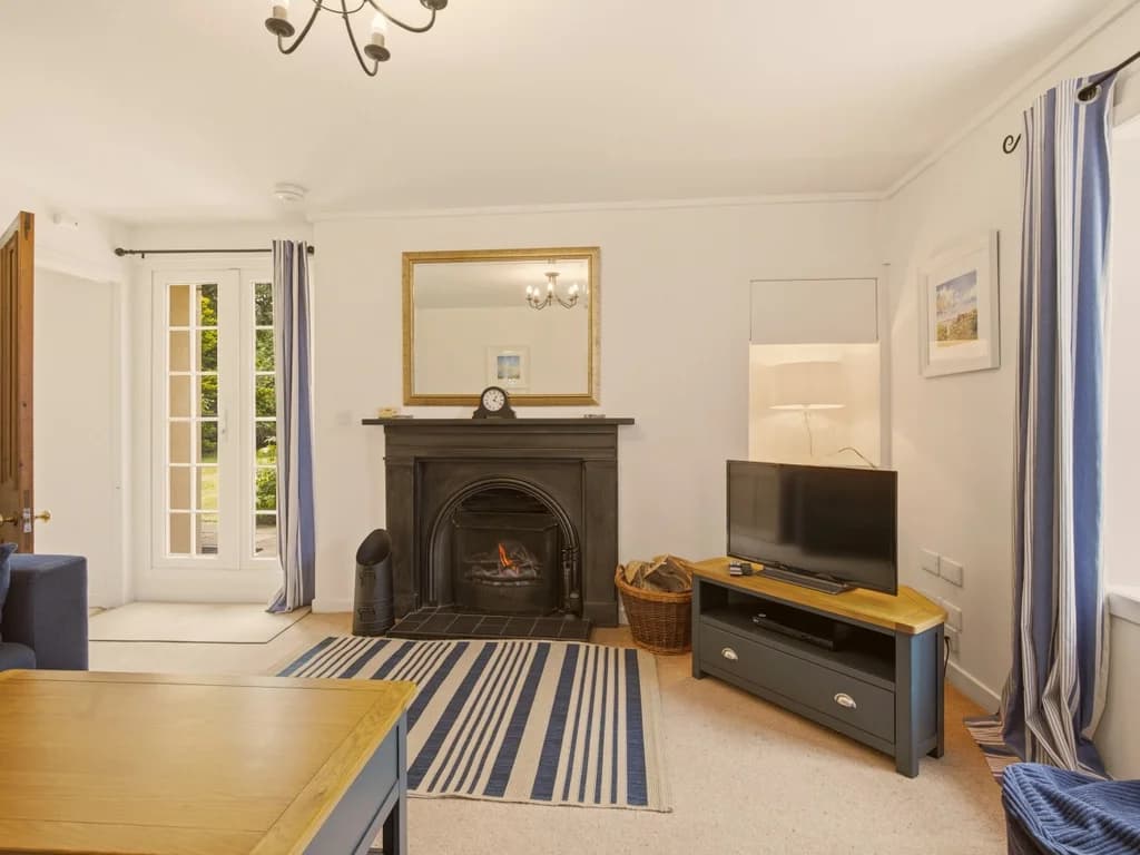 Cosy lounge with open fire, French doors and traditional cast iron fireplace