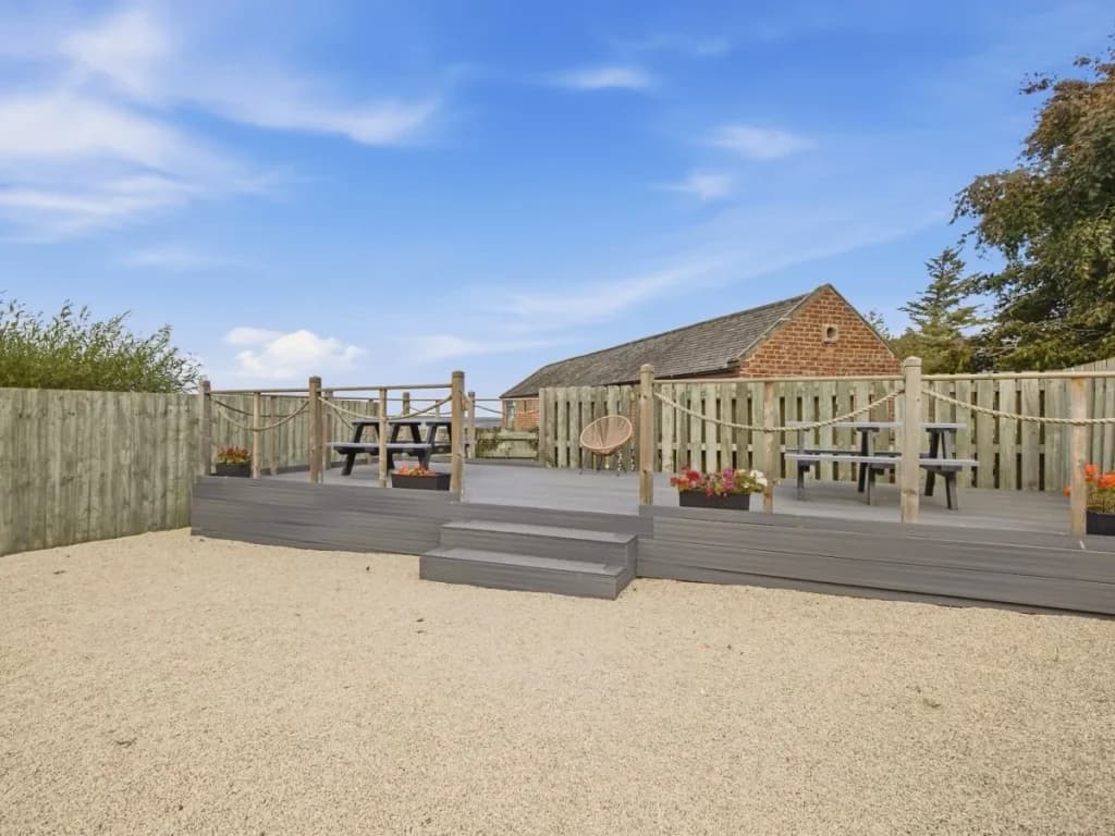 Enclosed decked area with outdoor seating overlooking the shared grounds