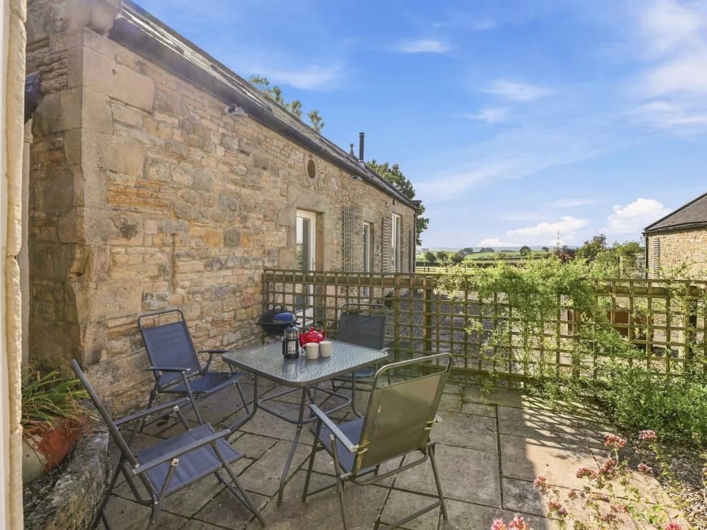 Private courtyard with outdoor seating and countryside views