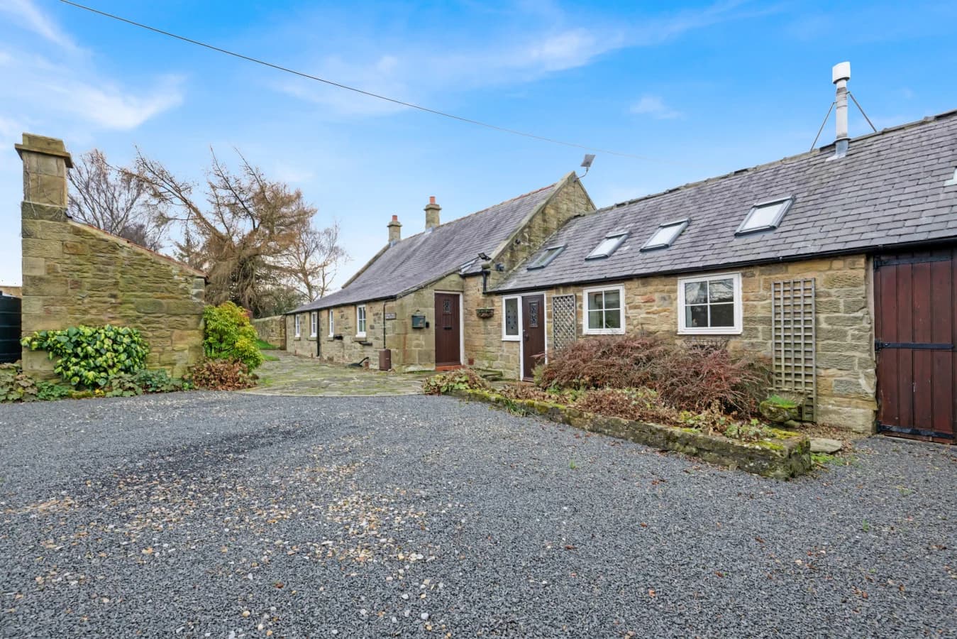 Gravel courtyard with ample parking and traditional stone buildings