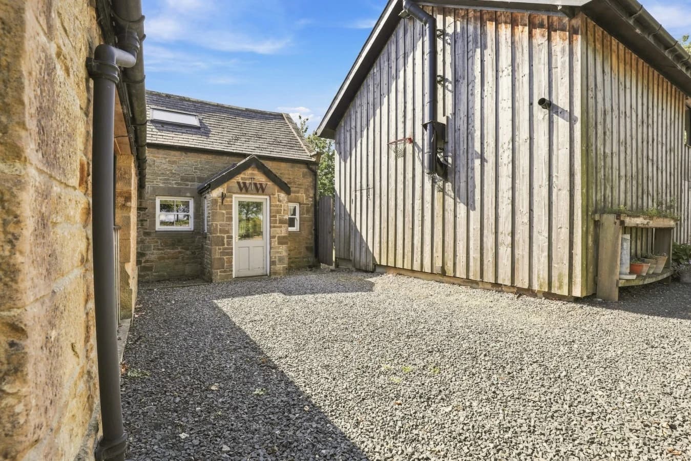 Woodworkers Cottage entrance with gravel courtyard and timber cladding