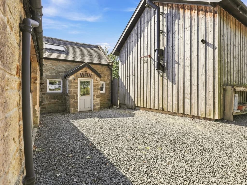 Woodworkers Cottage entrance with gravel courtyard and timber cladding