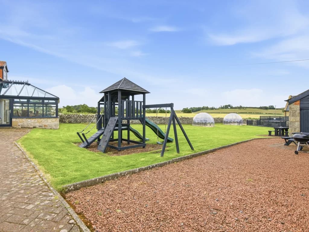 Shared play area with climbing frame and conservatory