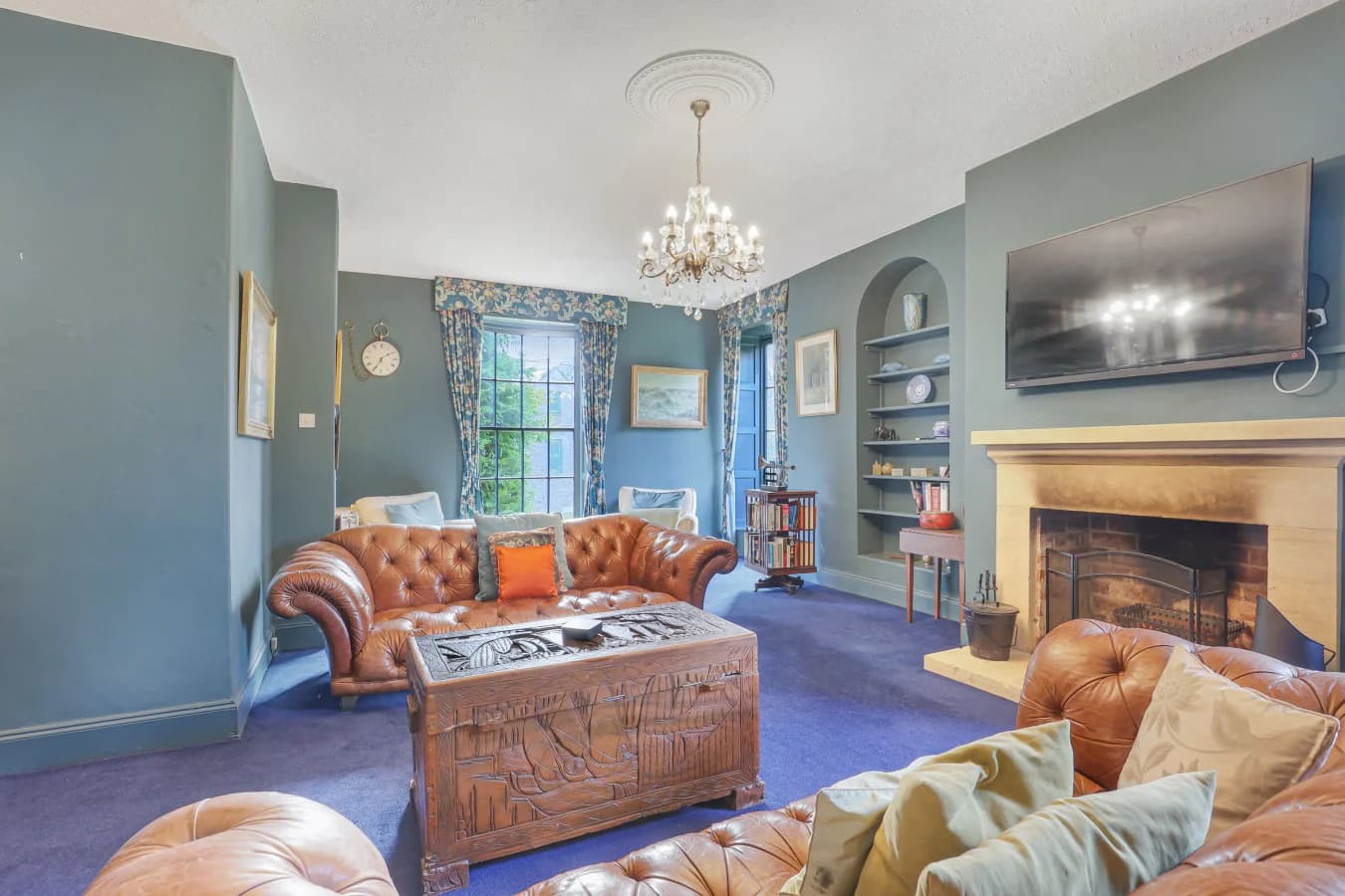 Elegant sitting room with leather sofas, open fire and blue accents
