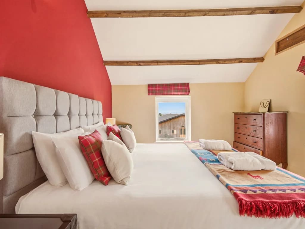 King-size bed with tartan accents, drawers and countryside views