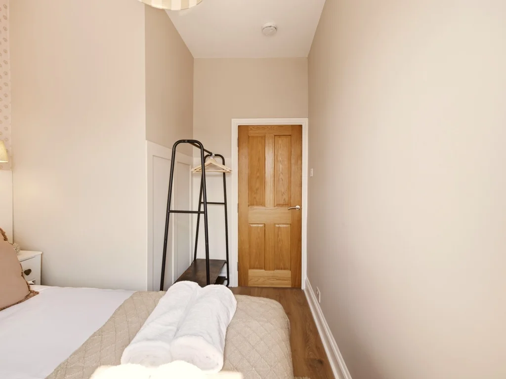 Double bedroom with bedside lighting and clothes hanging rail