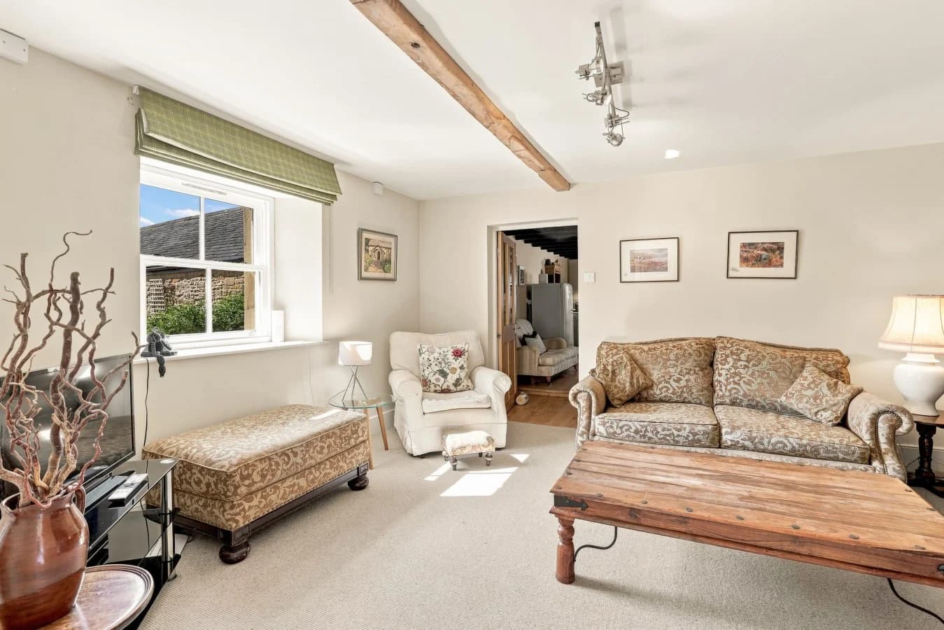 Bright living room with patterned sofa, armchair and wooden coffee table