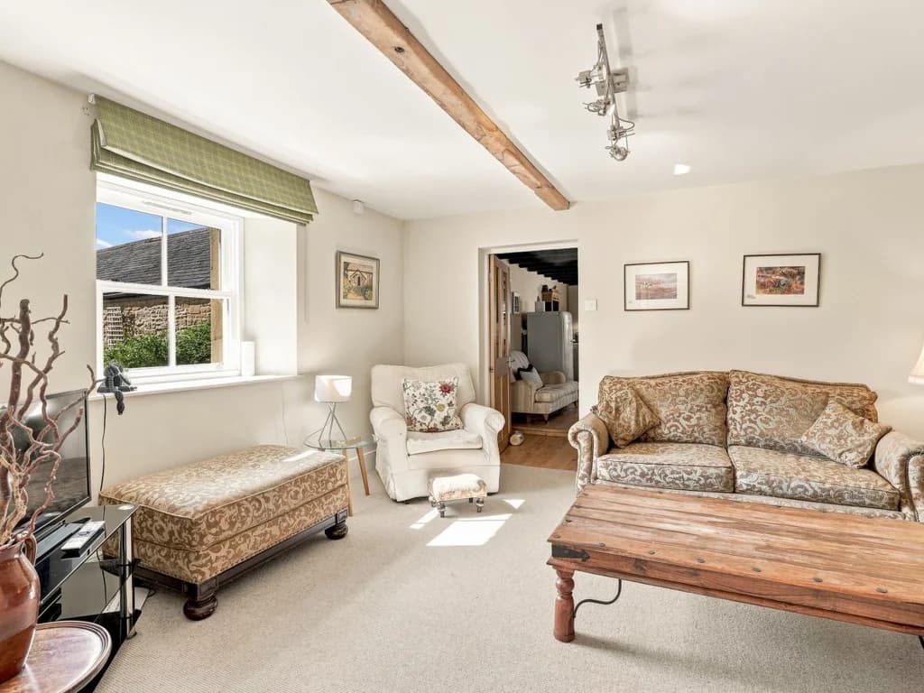 Bright living room with patterned sofa, armchair and wooden coffee table