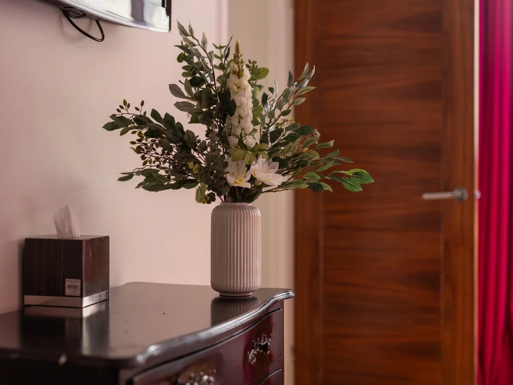 Dark wood dresser with floral arrangement and solid wood bedroom door