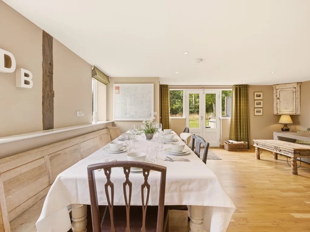 Long dining table with seating beside the bright open-plan kitchen