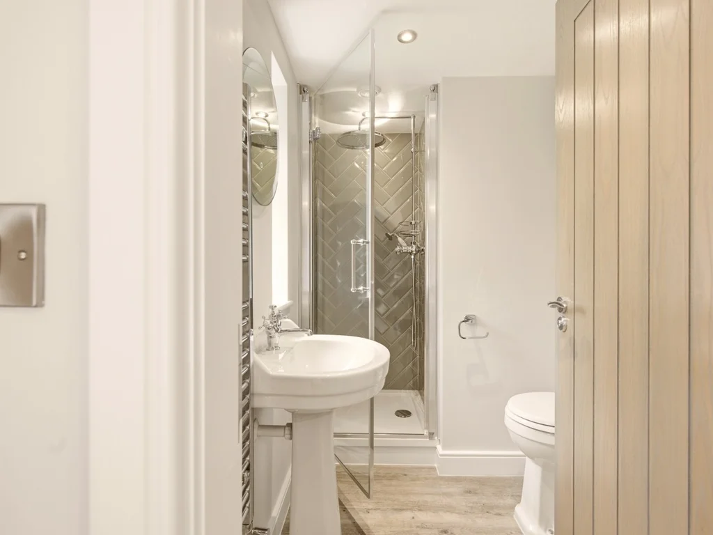 Modern en-suite shower room with herringbone tiles and chrome fittings