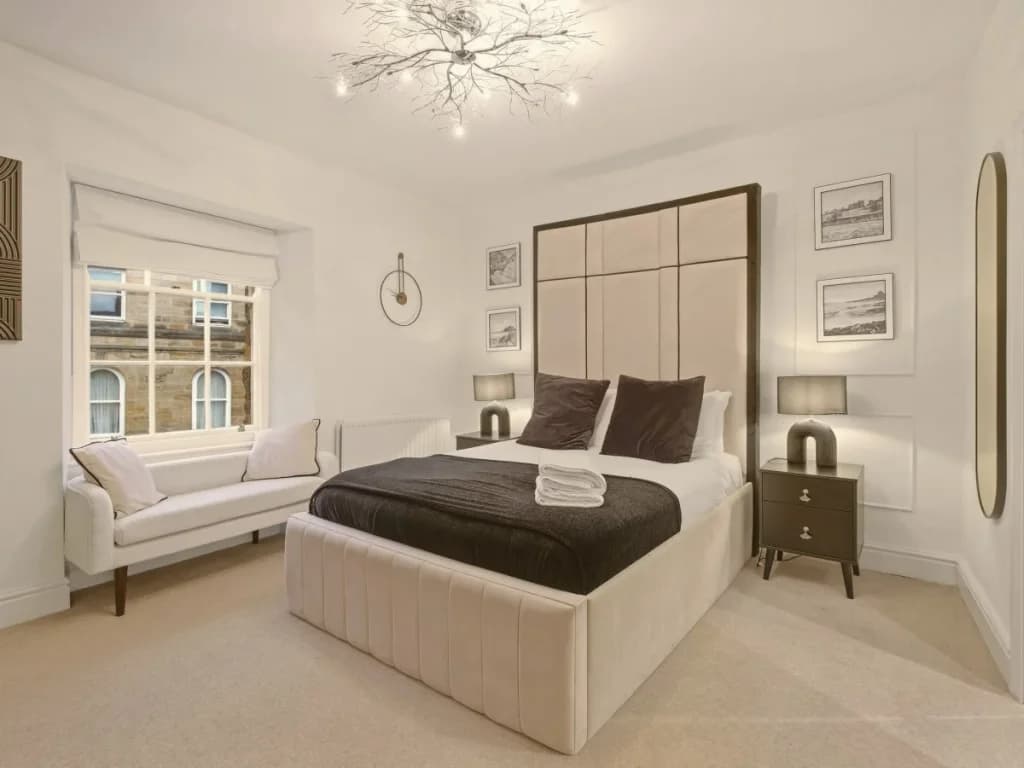 Second-floor king bedroom with full-length mirror and wooden wardrobe.