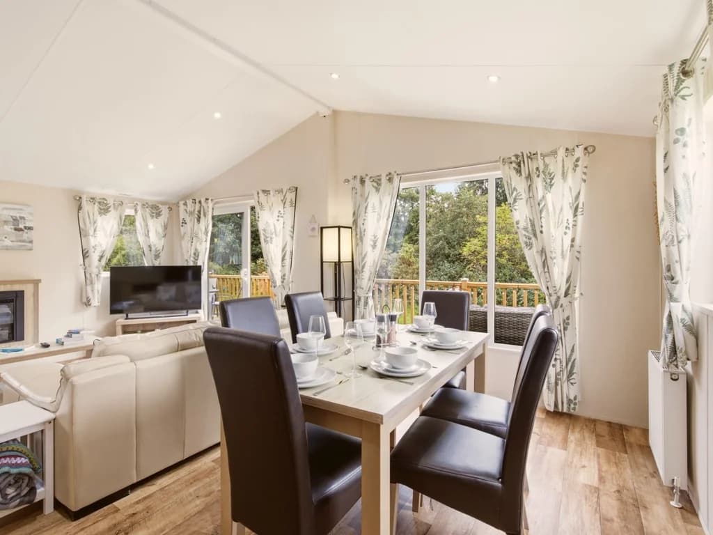 Dining area beside the lounge with large windows and access to the deck