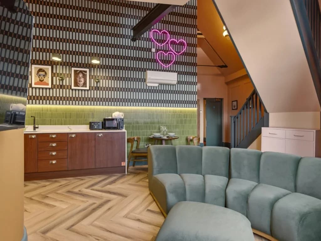 Kitchenette and lounge with patterned walls and mezzanine staircase