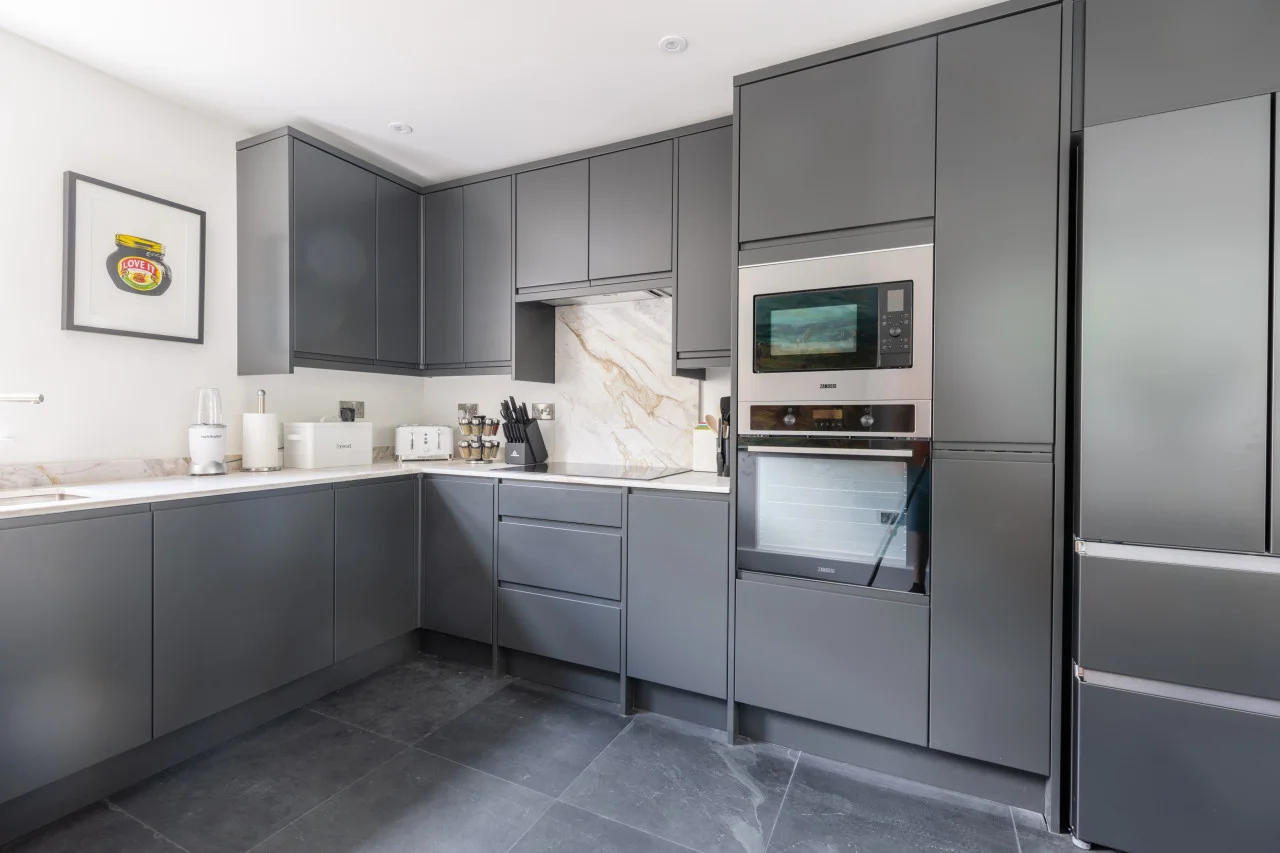 Contemporary kitchen with integrated appliances and marble-effect splashback