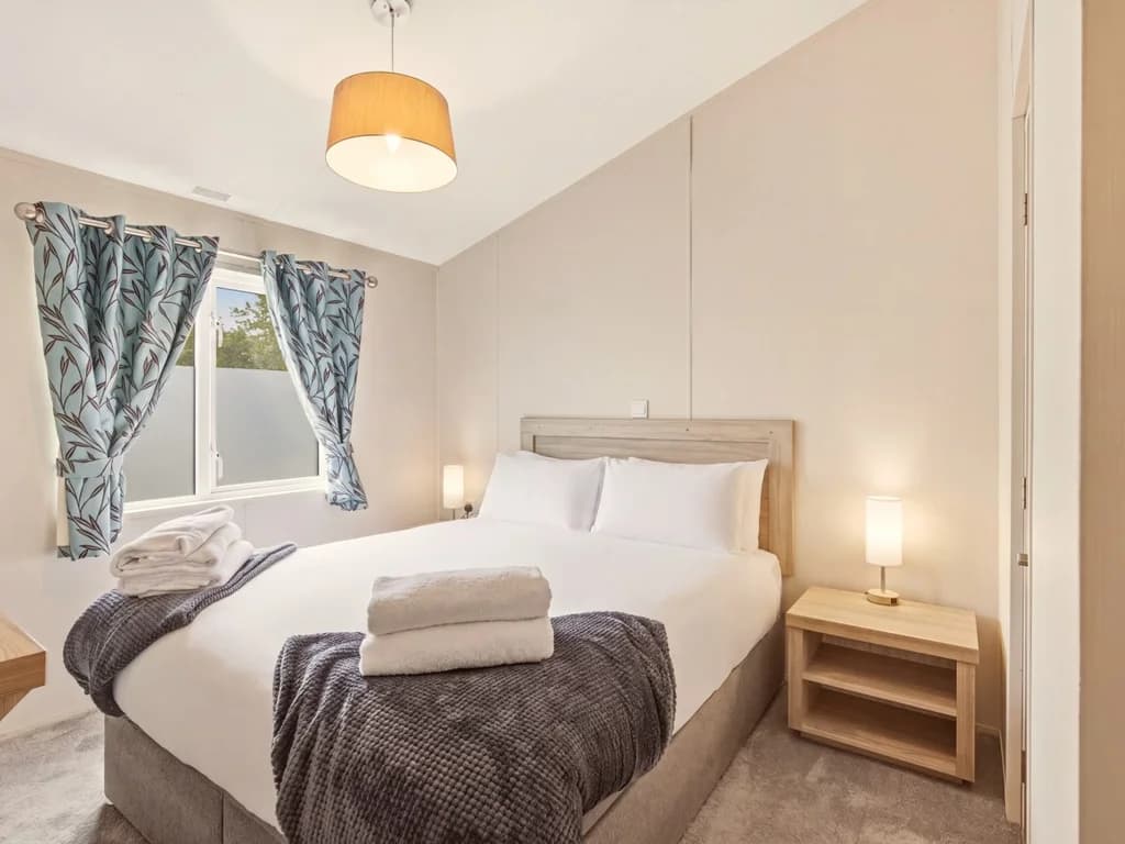 King-size bedroom with bedside lighting, wardrobe and garden-facing window