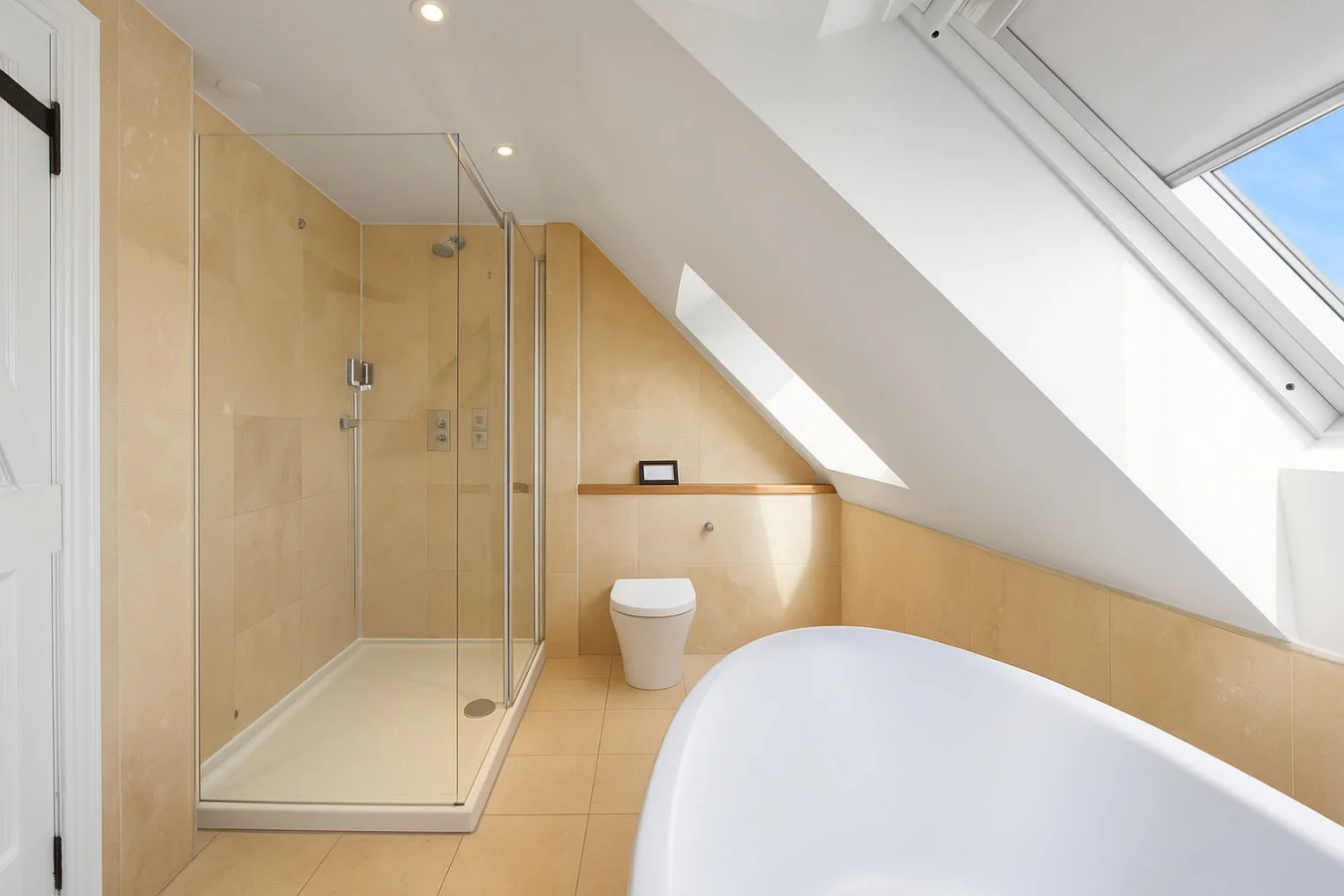 Family bathroom with freestanding bath, walk-in shower and skylight
