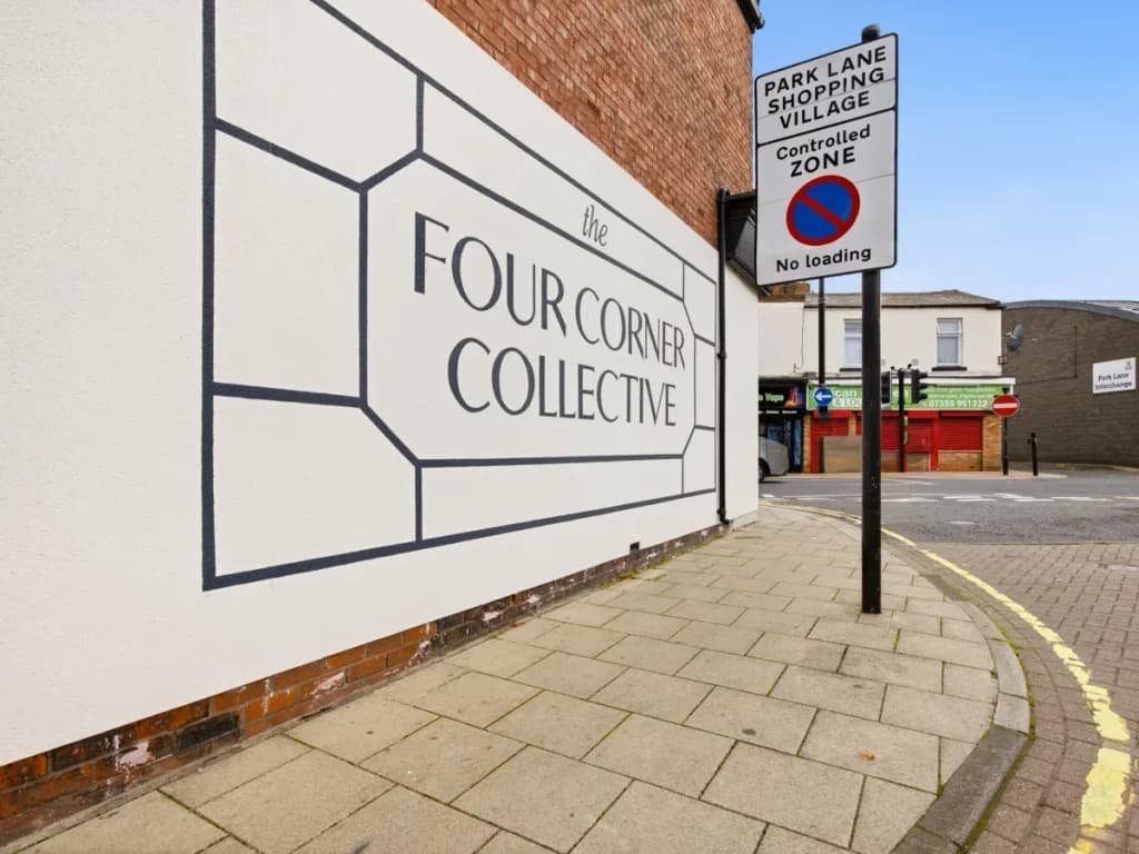 The Four Corner Collective wall signage beside the city-centre building.