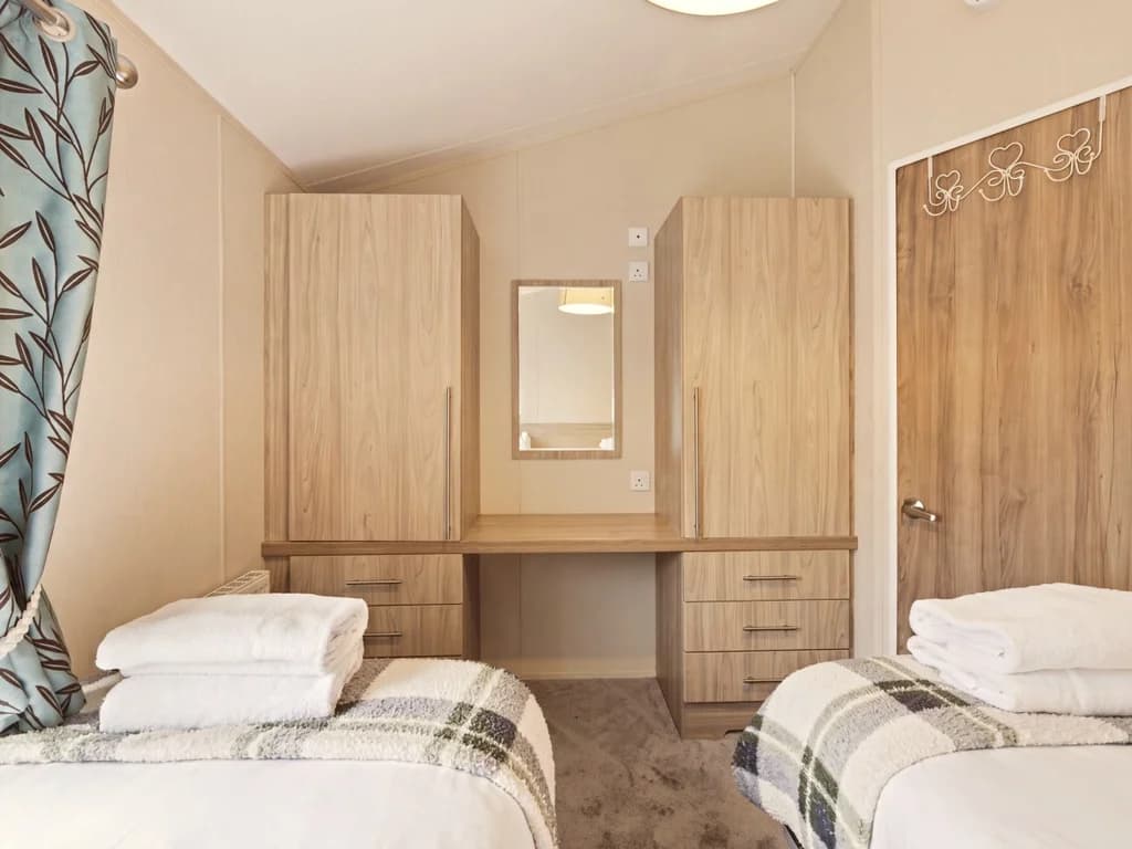 Twin bedroom with built-in wardrobes, dressing table and mirror
