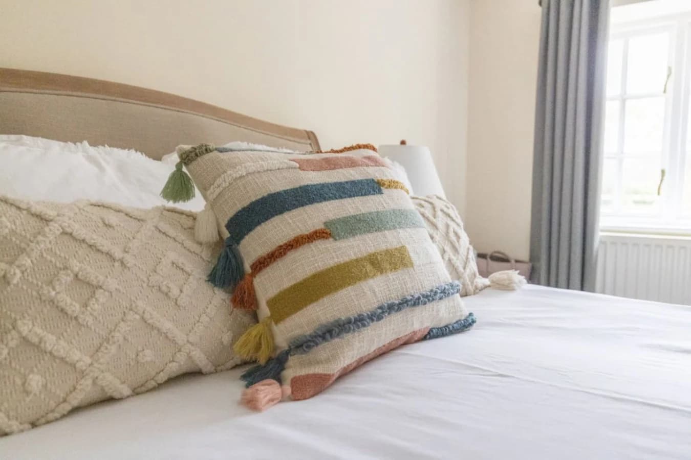 Textured cushions and soft linens add warmth to the king bedroom