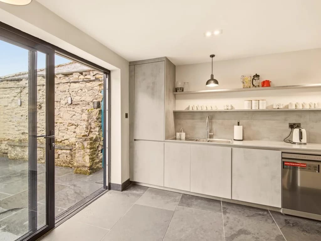 Contemporary kitchen with bi-fold doors opening onto the garden.