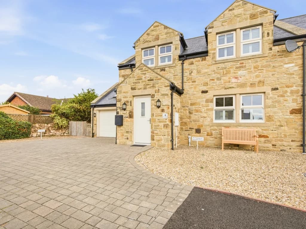 Front exterior of the property with stonework and private parking