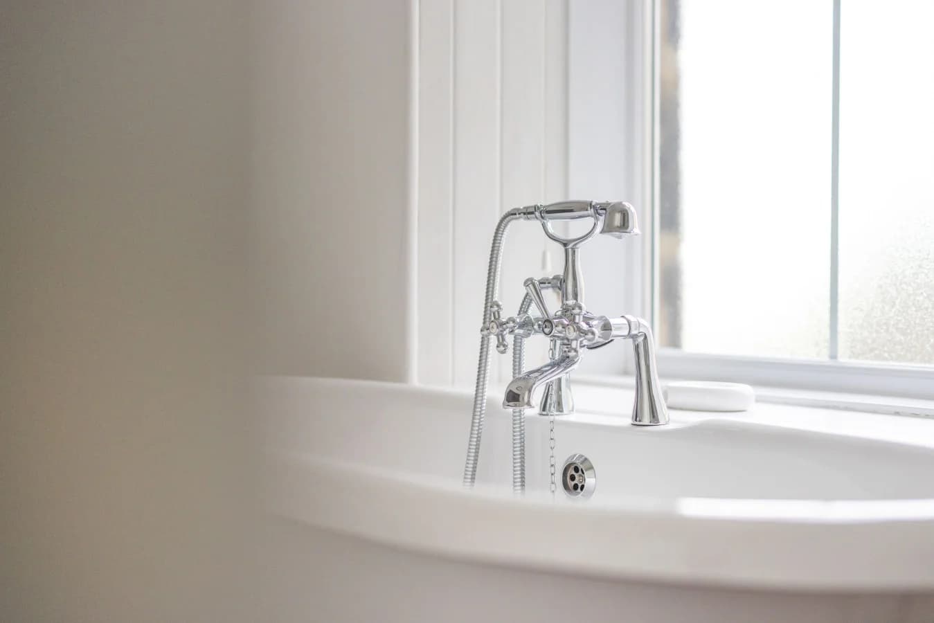 Freestanding bath beside sash window