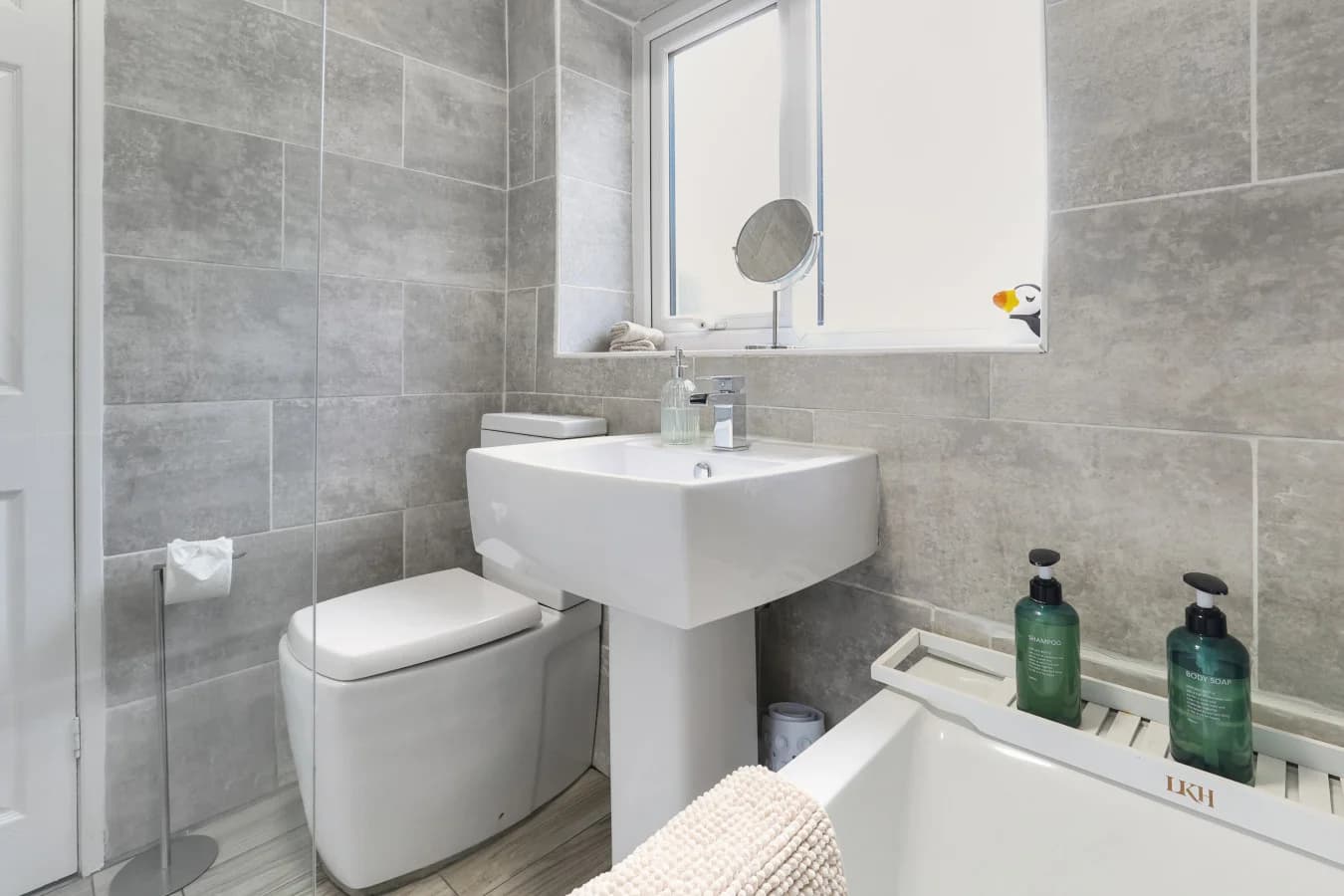 Modern bathroom with sleek fittings, stone-effect walls and natural light