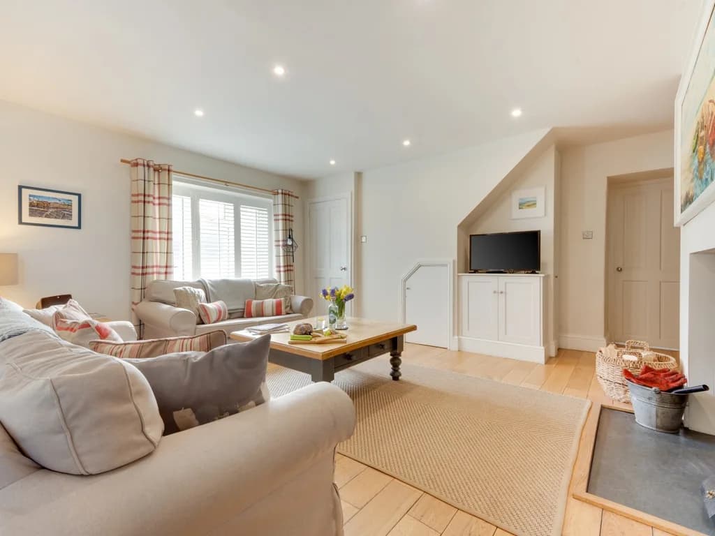 Bright and comfortable living room with generous seating, Smart TV and a cosy wood-burning stove.