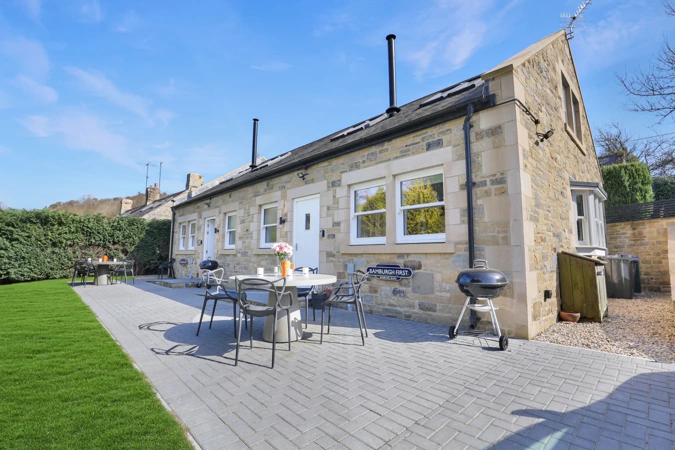 Stone-built cottage with paved patio, outdoor dining set and lawn