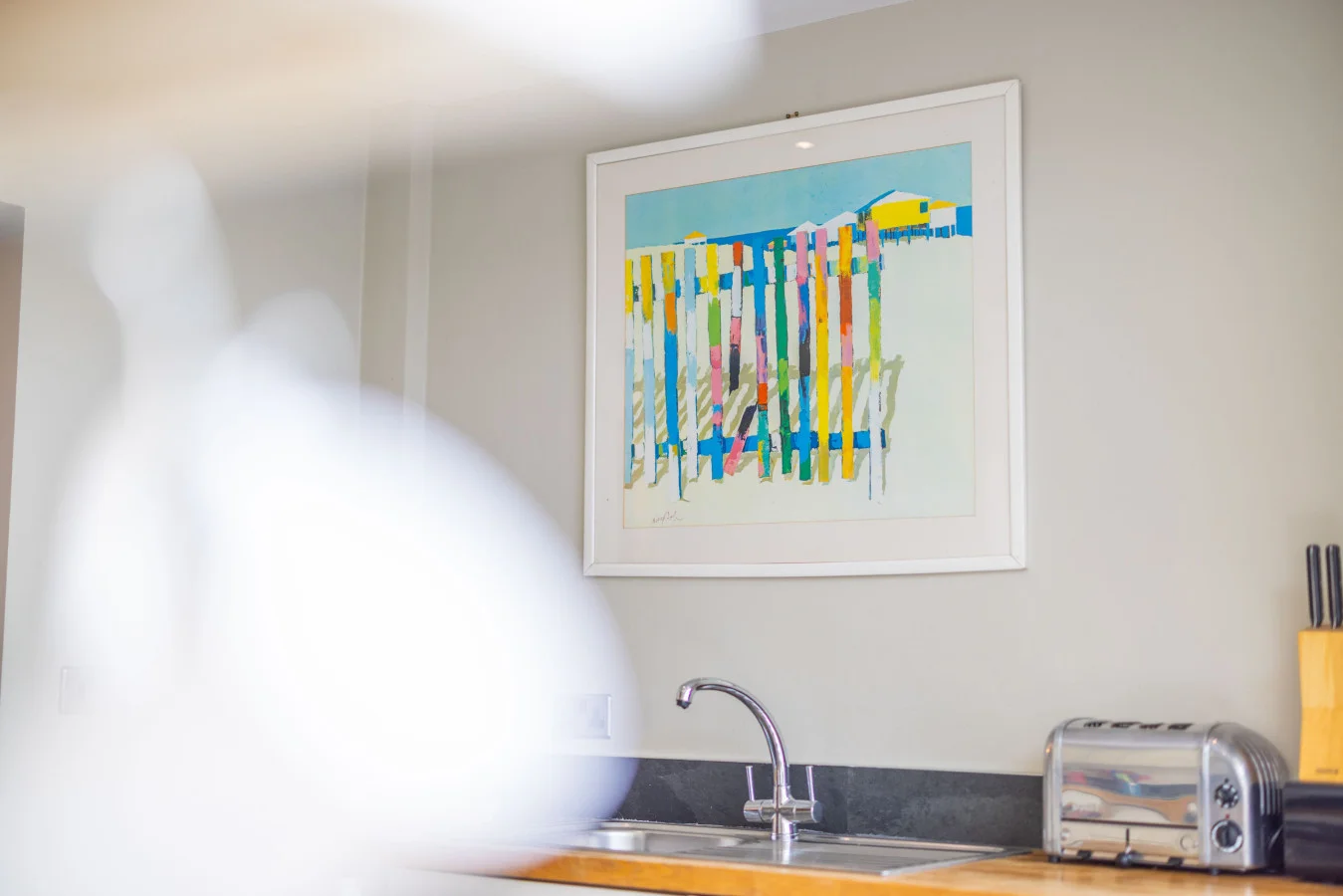 Timber worktop, Belfast sink and colourful kitchen artwork