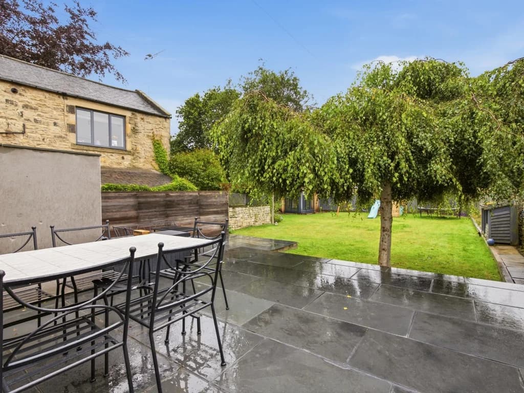 Patio with outdoor dining overlooking the enclosed garden, perfect for al fresco meals and relaxing.