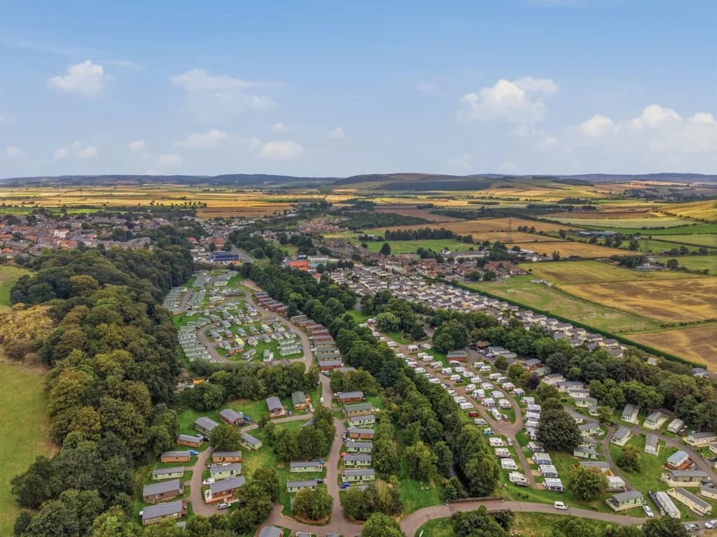 Aerial view of Riverside Holiday Park with Wooler and countryside beyond